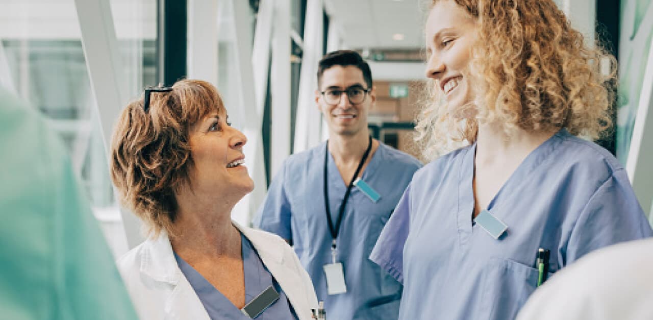 A trio of nurses smiling at each other