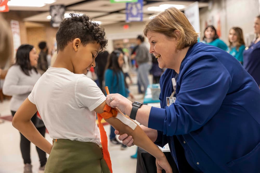 Nurse helping a boy with a tourniquet